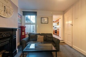 Cozy living space with a sofa, coffee table, and kitchen area.