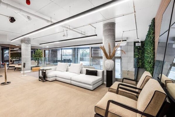 Relax in style with a sofa by the window, surrounded by a seating area and lush greenery.