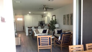 A spacious living area with a dining table and chairs, a sofa, and a kitchen in the background. - Fabulous beachfront condo (Treasure Cay)