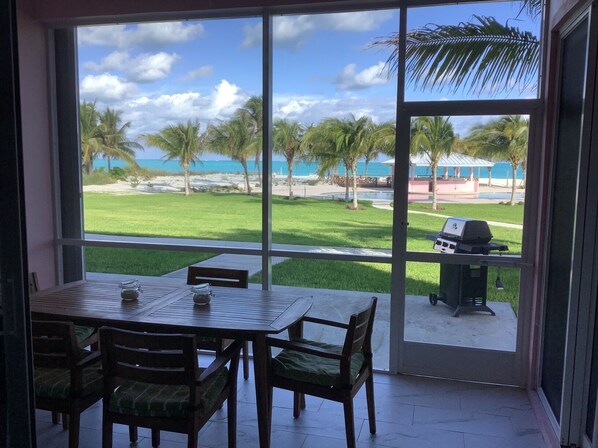 Zona pranzo con vista sulla spiaggia e palme.