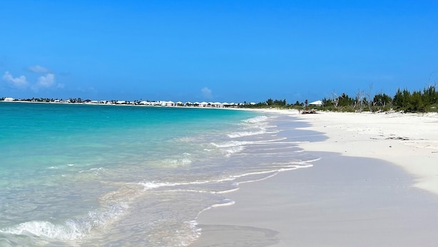 A beach with clear turquoise water, white sand, and a clear blue sky. - Fabulous beachfront condo (Treasure Cay)