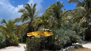A sandy beach with a yellow sign for Pete's Pub Gallery. - Fabulous beachfront condo (Treasure Cay)