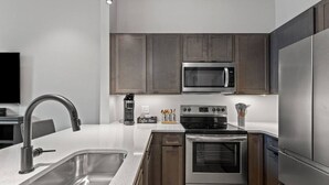 A modern kitchen with stainless steel appliances, a built-in microwave, and a coffee station. - The Gatsby Getaway, Downtown LEX (Lexington)