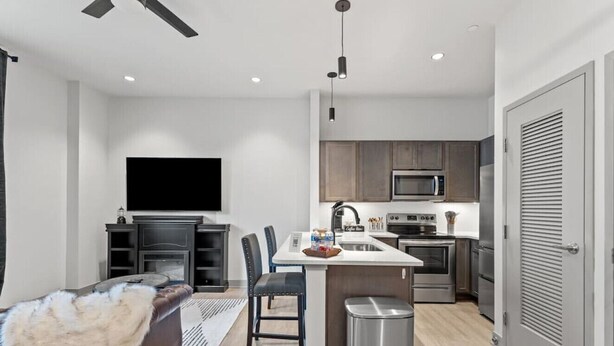 A modern kitchen with a central island, built-in microwave, and stainless steel appliances. - The Gatsby Getaway, Downtown LEX (Lexington)