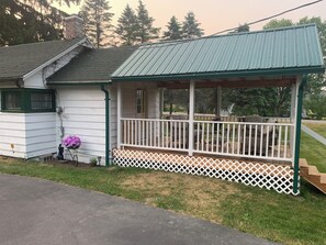 A small, single-story house with a porch and a covered area. - Cozy, upgraded, pet friendly cabin, formerly Cuba Lake Vintage Duck House. (Cuba)