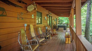 A wooden cabin with a porch featuring several rocking chairs and a pool table. - Creekfront Cabin w/ Hot Tub! Motorcycle Friendly! (Robbinsville)