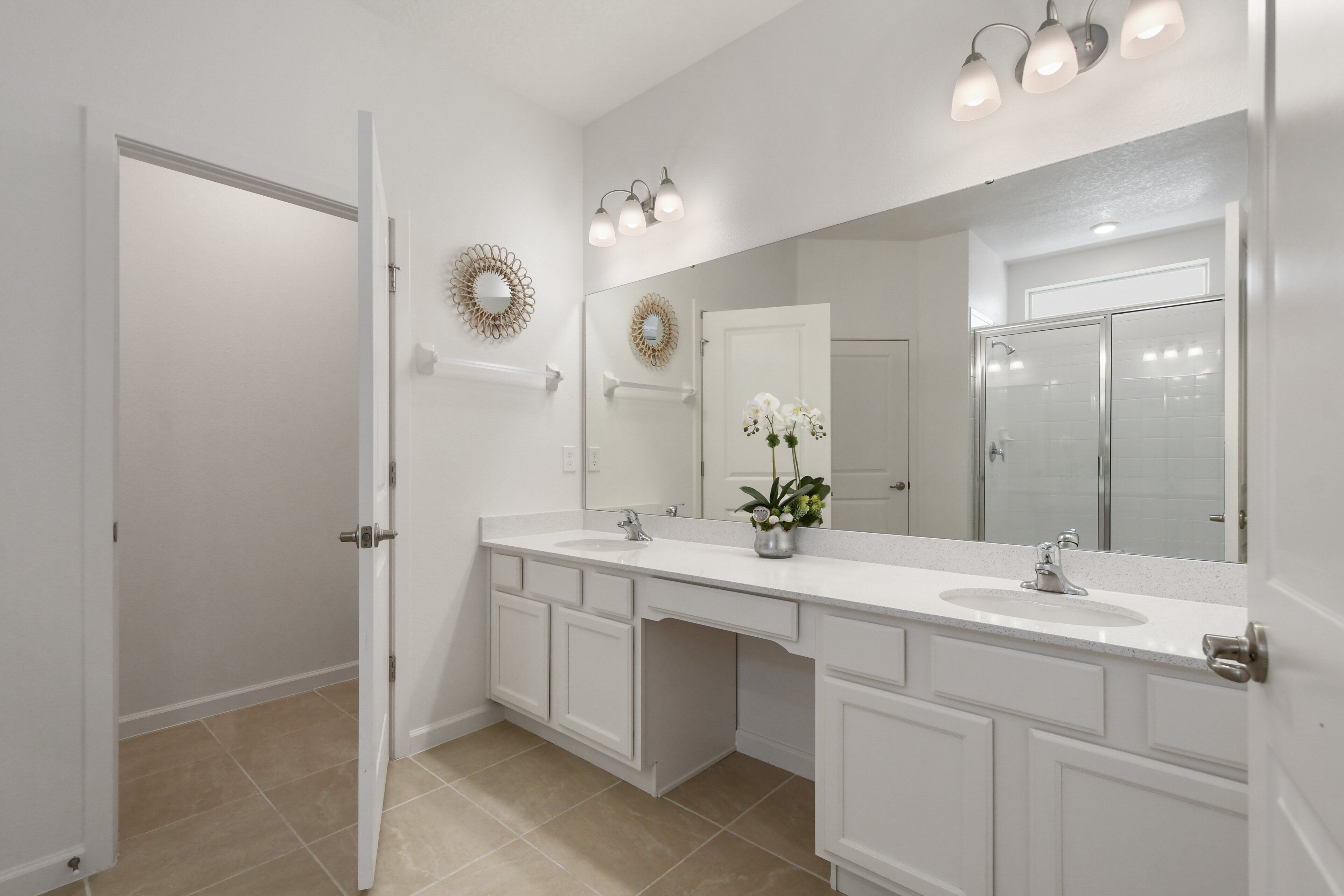 Une salle de bain moderne avec un meuble-lavabo à deux vasques, un grand miroir et un espace douche.
