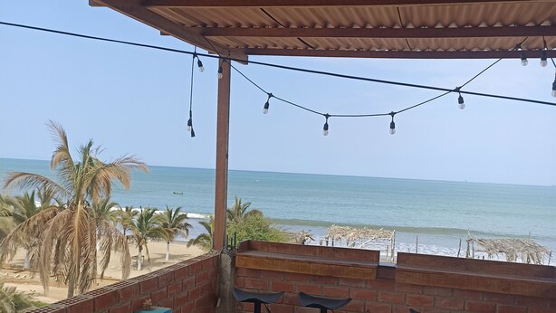 Ein überdachter Sitzbereich mit Blick auf Strand und Meer.
