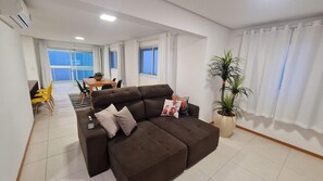 Relax in this stylish living room with a sofa, dining area, and potted plant.