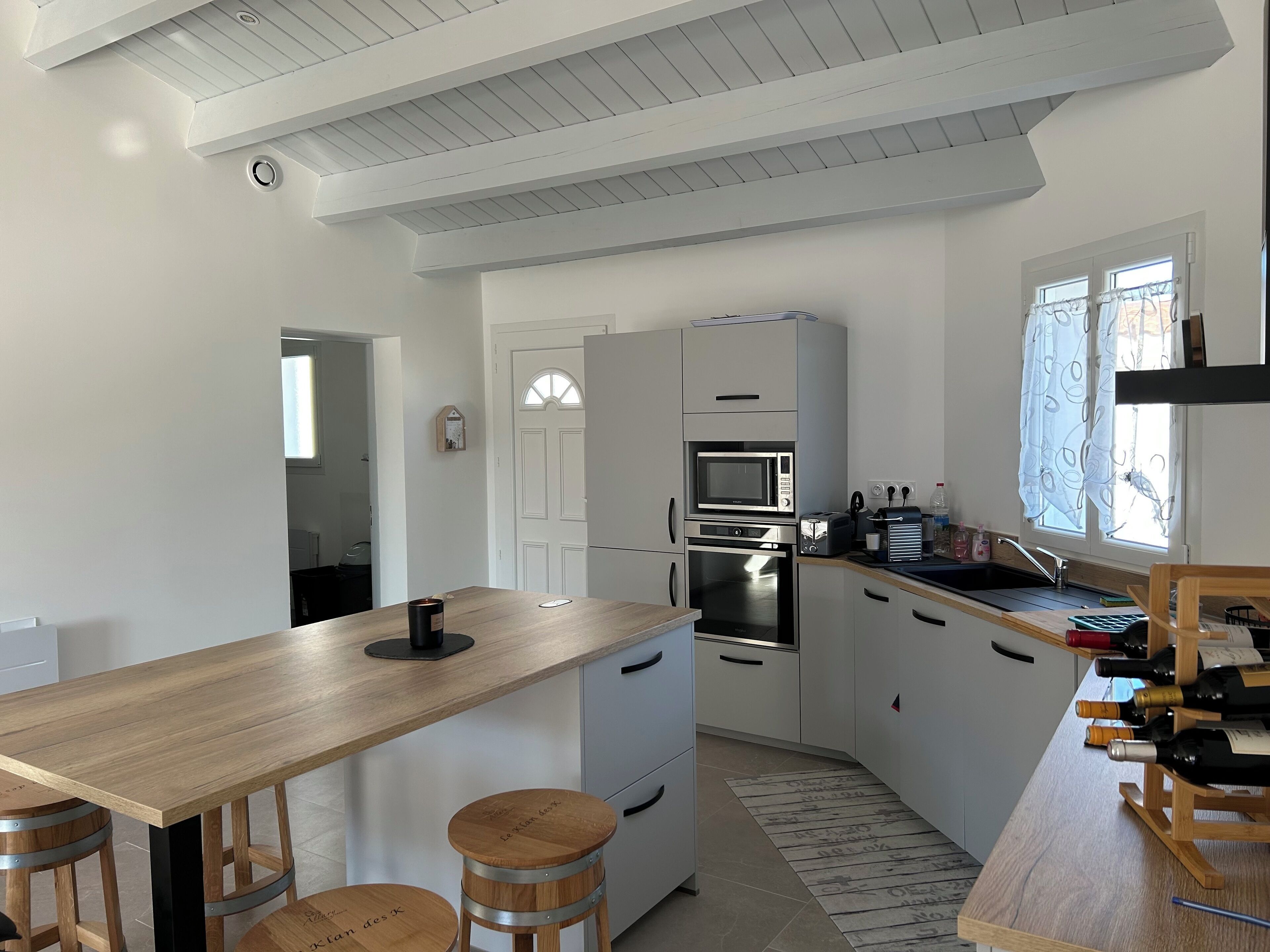 Una cocina moderna con una isla de madera, electrodomésticos de acero inoxidable y una estantería para vinos.