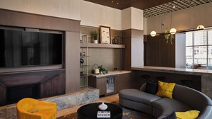 Un salon moderne doté d’un grand téléviseur à écran plat, d’une cheminée, d’un canapé et d’une table basse.