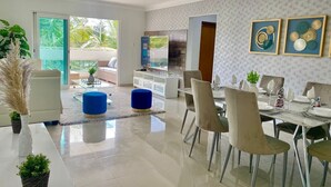 Una sala de estar moderna con comedor, ventanas amplias y vistas al exterior.