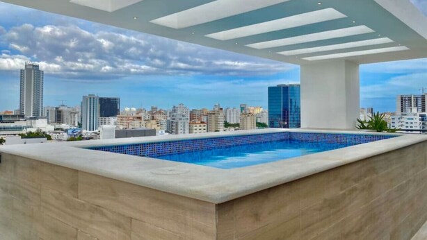 Una piscina en la azotea con vistas al horizonte urbano.