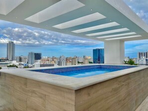 Una piscina en la azotea con vistas al horizonte urbano.