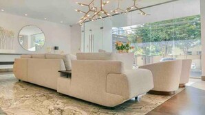 Ein modernes Wohnzimmer mit einer großen Couch, einem Couchtisch und einem außergewöhnlichen Kronleuchter.