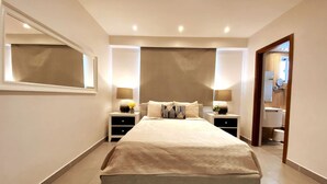 A modern bedroom with a large bed, bedside tables, and a mirror.
