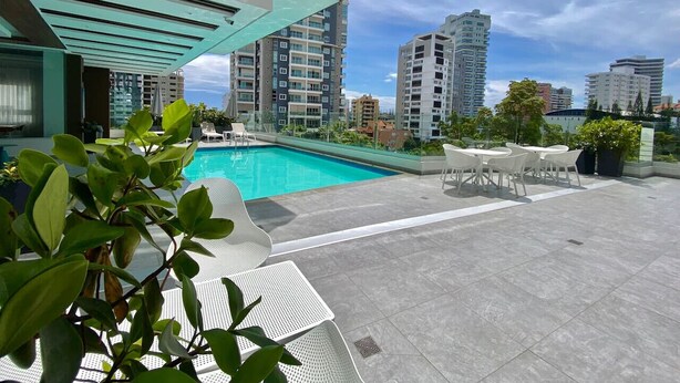 A rooftop pool area with a clear view of surrounding high-rise buildings. - Elegant, Finely Decorated City Center 2 Bdrm Condo, Pool, Near All (Santo Domingo)