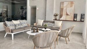 A modern living room with a sectional sofa, two armchairs, and a coffee table. - Elegant, Finely Decorated City Center 2 Bdrm Condo, Pool, Near All (Santo Domingo)
