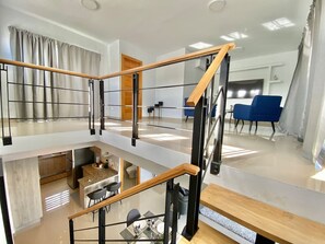 Un espacio habitable distribuido en varios niveles, con cocina, comedor y zona de estar.