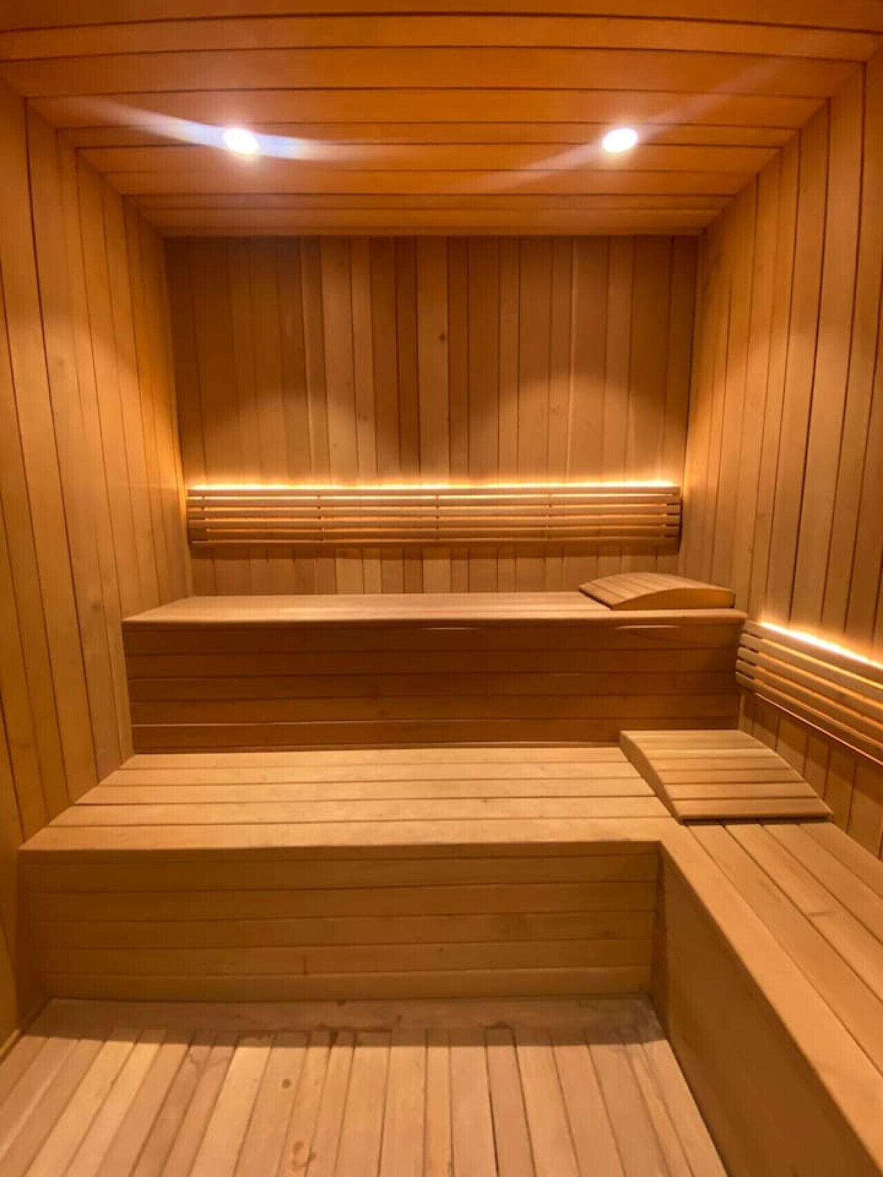 A wooden sauna with benches and a bench seat.
