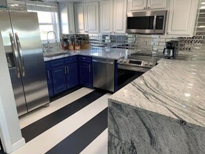 Fully equipped kitchen with refrigerator, oven, microwave, and coffee maker.
