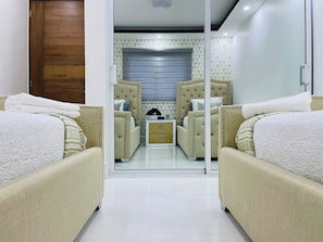 Relax in a stylish room with a large bed, geometric patterned walls, and a window offering a view of the outside.