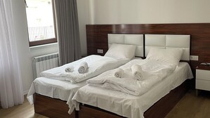 A double bed with white linens, a wooden headboard, and a nightstand with a lamp. - Luxury apartment on av. Melikishvili with huge balcony, city center  (T'bilisi)