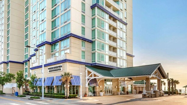 A multi-story hotel with a prominent entrance and a covered outdoor area.