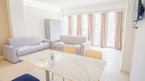 Ein modernes Wohnzimmer mit einem Marmortisch, zwei grauen Sofas und einem Schrank.