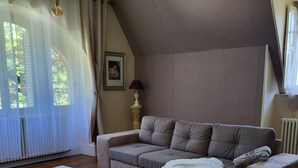 Una sala de estar acogedora con un sofá modular, una mesa de centro de vidrio y una alfombra mullida.