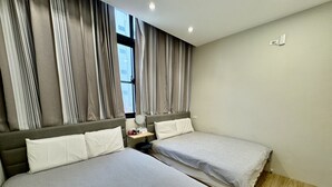 A hotel room with two beds, a nightstand, a mirror, and a window with curtains. - Liu-He 914 Hostel (Kaohsiung)