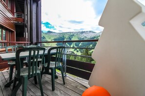 A balcony with a table and chairs, overlooking a mountainous landscape. - Beautiful 2-bed Family Apartment, Flaine Montsoleil (Flaine)