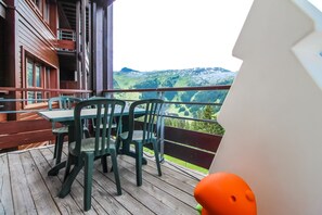 A wooden deck with a table and chairs, overlooking a mountainous landscape. - Beautiful 2-bed Family Apartment, Flaine Montsoleil (Flaine)