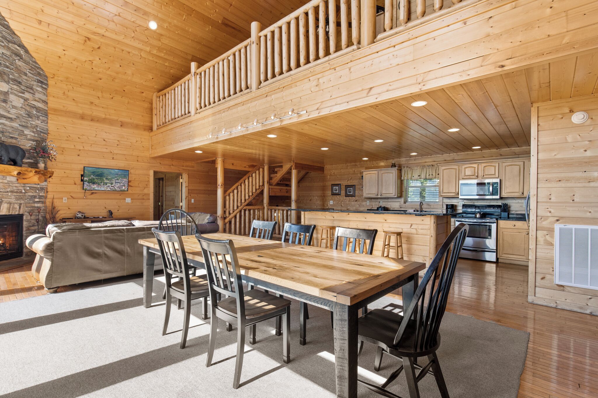Un intérieur spacieux en bois, comprenant un coin repas, une cuisine et une cheminée.