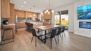 A modern kitchen with wooden cabinets, a central island, and black chairs.