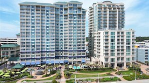 A high-rise hotel with multiple balconies, a swimming pool, and a landscaped courtyard. - Diamond Resorts Ocean Beach Club - 3 BDR Suite - Ocean Front (Virginia Beach)