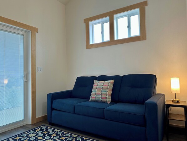 A living room with a blue sofa, a patterned throw pillow, a small table with a lamp, and a window above the sofa. -
European Style Cottage in Oregon's Willamette Valley Wine Country - Cottage #3 (Dundee)