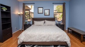 A bedroom with a large bed, two bedside tables, a bench, a floor lamp, and a ceiling fan. - Poolside Paradise Terramar Family Safe Retreat Beautiful Northwest Peoria (Peoria)
