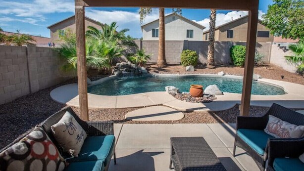 A covered patio area with a pool, outdoor furniture, and a view of a residential building. - Poolside Paradise Terramar Family Safe Retreat Beautiful Northwest Peoria (Peoria)