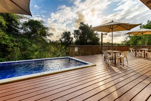 A wooden deck with a swimming pool, outdoor furniture, and umbrellas. - Sítio de Praia (Porto Seguro)