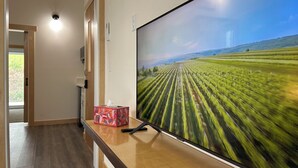 A flat-screen TV mounted on a wooden wall, displaying a field.