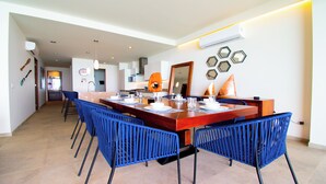 A dining area with a wooden table, blue chairs, and hexagonal mirrors on the wall. - Casa del Mar by Kivoya (Bucerías)