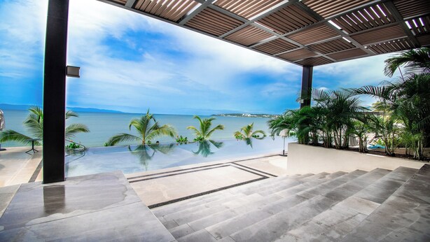 A modern outdoor terrace with a clear view of the ocean and a distant coastline. - Casa del Mar by Kivoya (Bucerías)