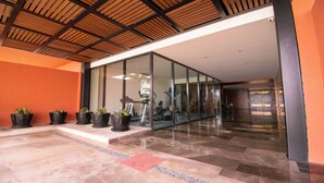 A modern building entrance with a glass facade, potted plants, and a tiled floor. - Casa del Mar by Kivoya (Bucerías)