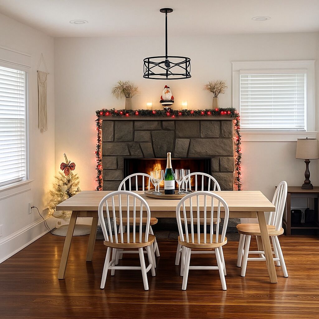 Un coin repas avec une cheminée, des chaises blanches et une table dressée pour quatre personnes.