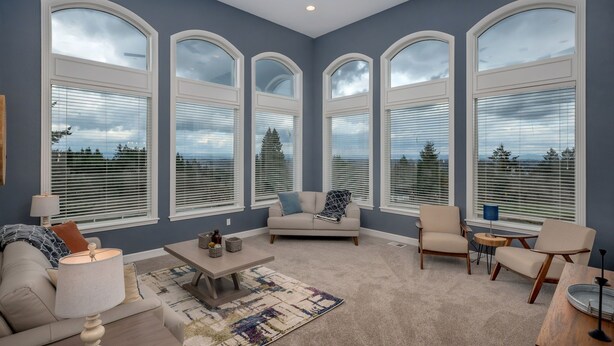 A spacious living room with a large window, a ceiling fan, and a cozy seating area. - Rosie's Retreat (Cornelius)
