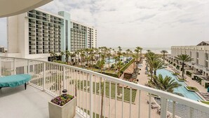 A hotel with a pool area, palm trees, and a view of the ocean. - Beachfront Vacation Condo at the Sapphire (South Padre Island)