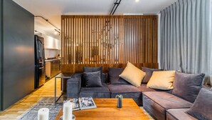 Ein modernes Wohnzimmer mit einem Ecksofa, einem Couchtisch und einer Wand mit Holzverkleidung.