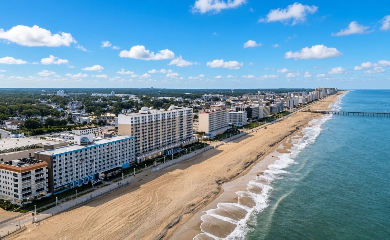 Un hôtel situé sur la côte, avec plusieurs étages, une promenade de bord de mer et une jetée qui s’avance dans l’océan.