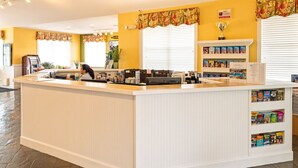 A reception area with a counter, a coffee machine, and a bookshelf with magazines. - Orlando | Couples Lake Retreat | Pool + Hot Tub (Orlando)
